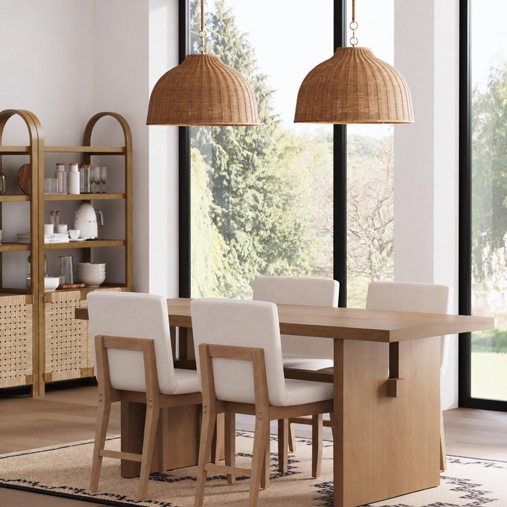 A dining room with a wooden table, four upholstered chairs, and two dome-shaped wicker pendant lights hanging above.