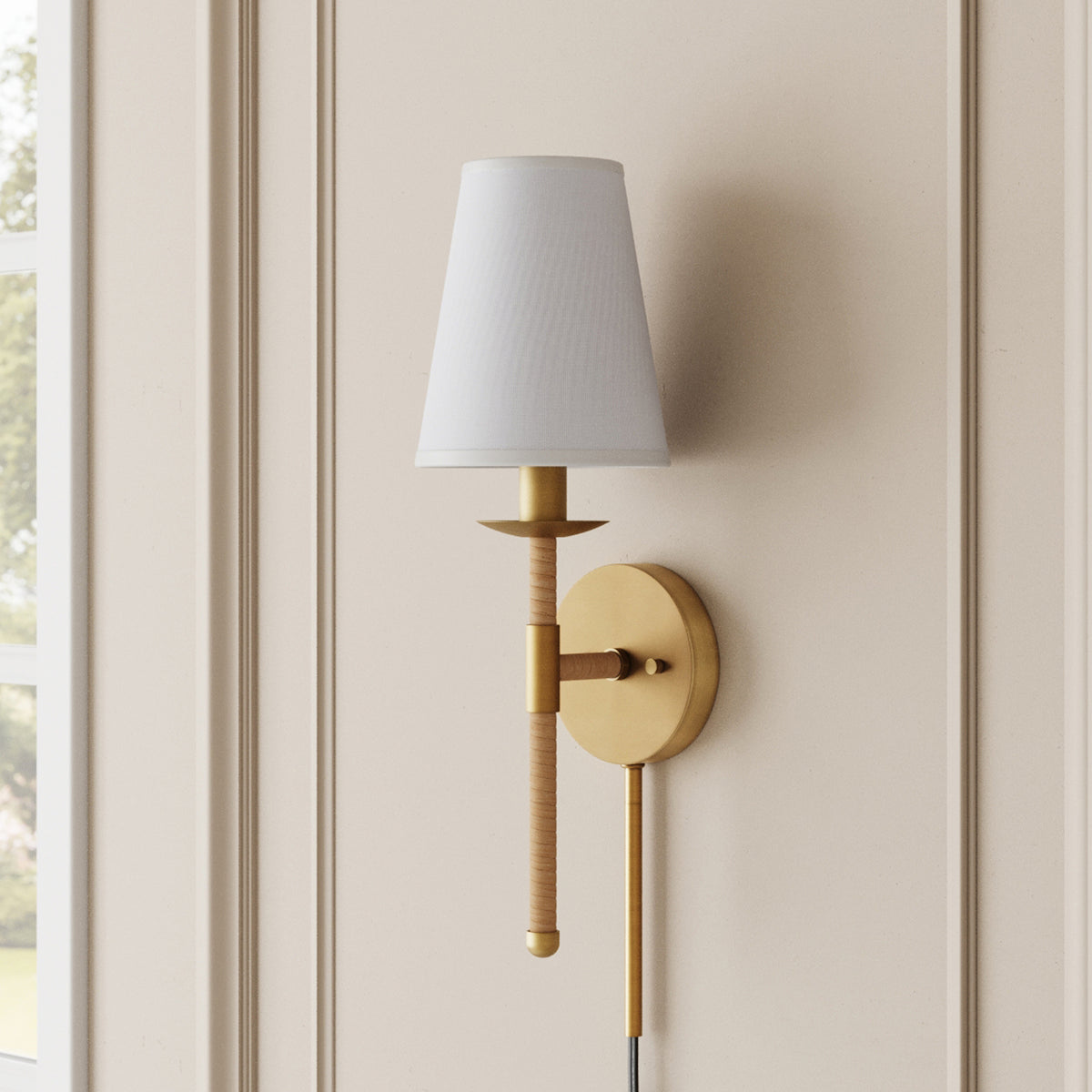 Wall-mounted lamp with a gold-finished circular base, a wrapped vertical arm, and a tapered white fabric shade.