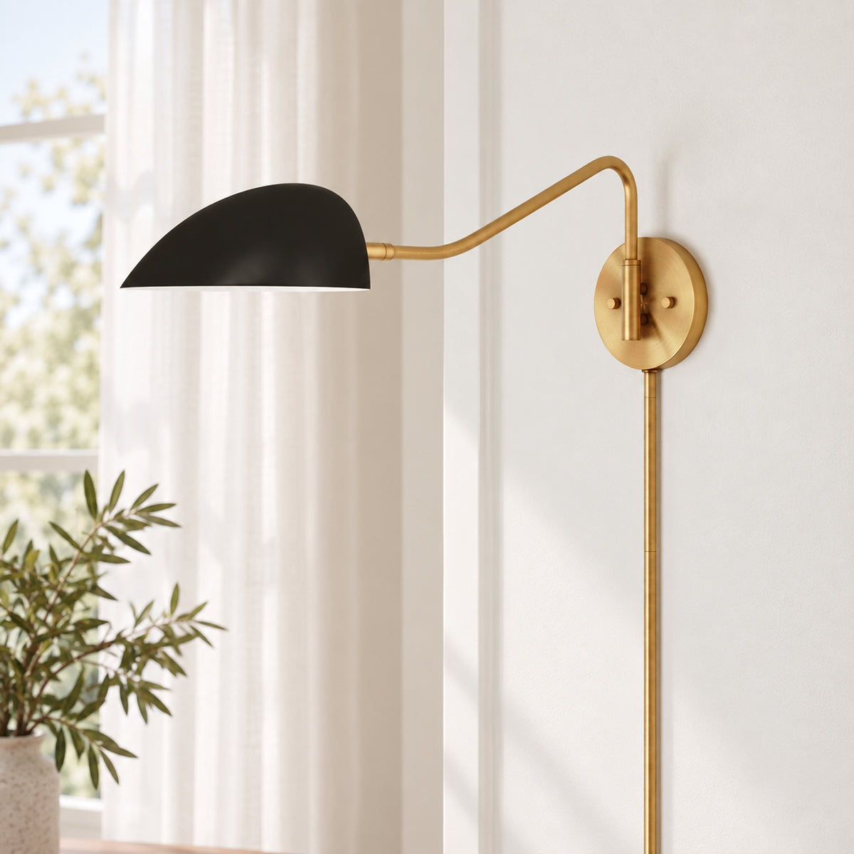 Gold-toned adjustable wall sconce with a matte black shade.