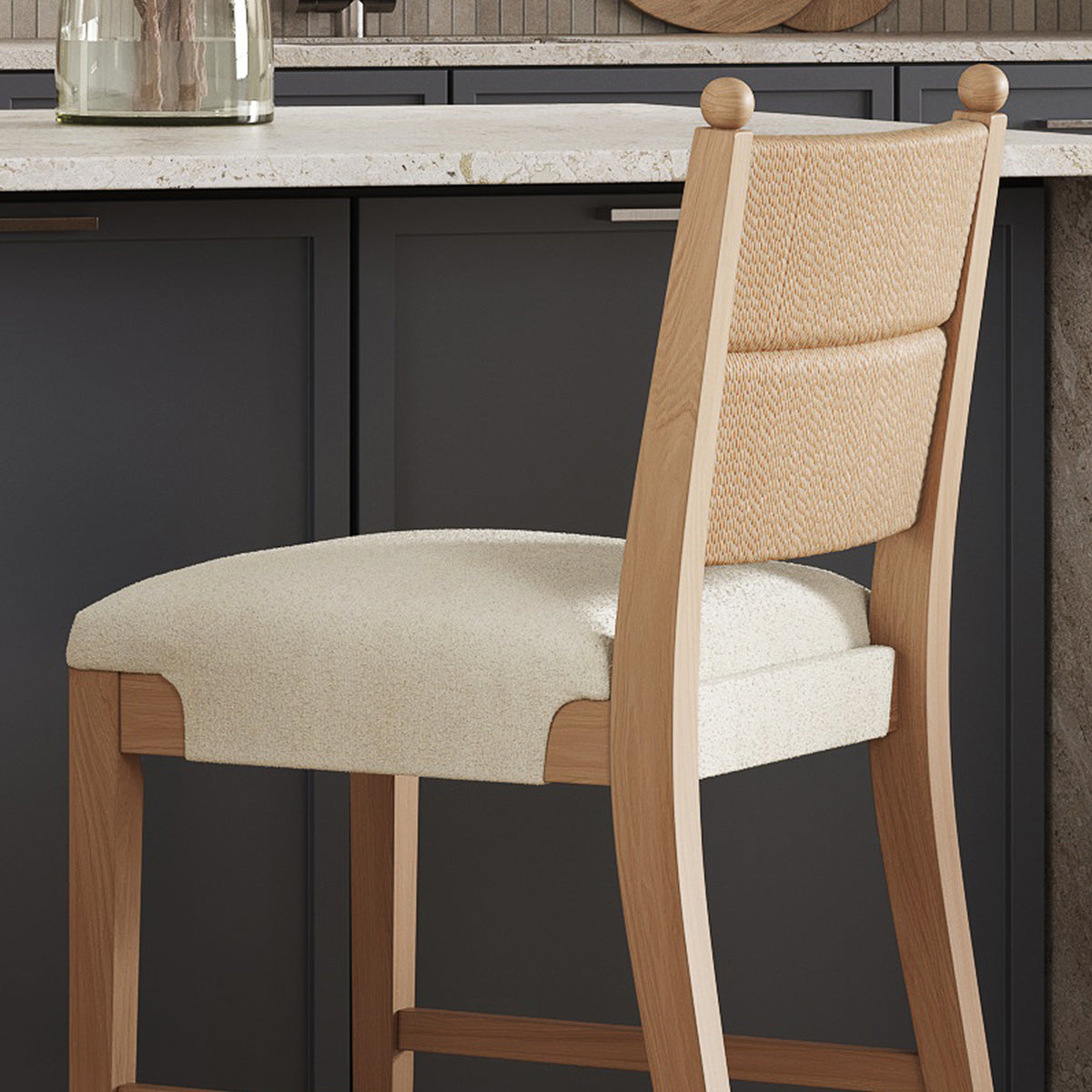 Light wood bar stool with a textured fabric seat and woven backrest in a kitchen.
