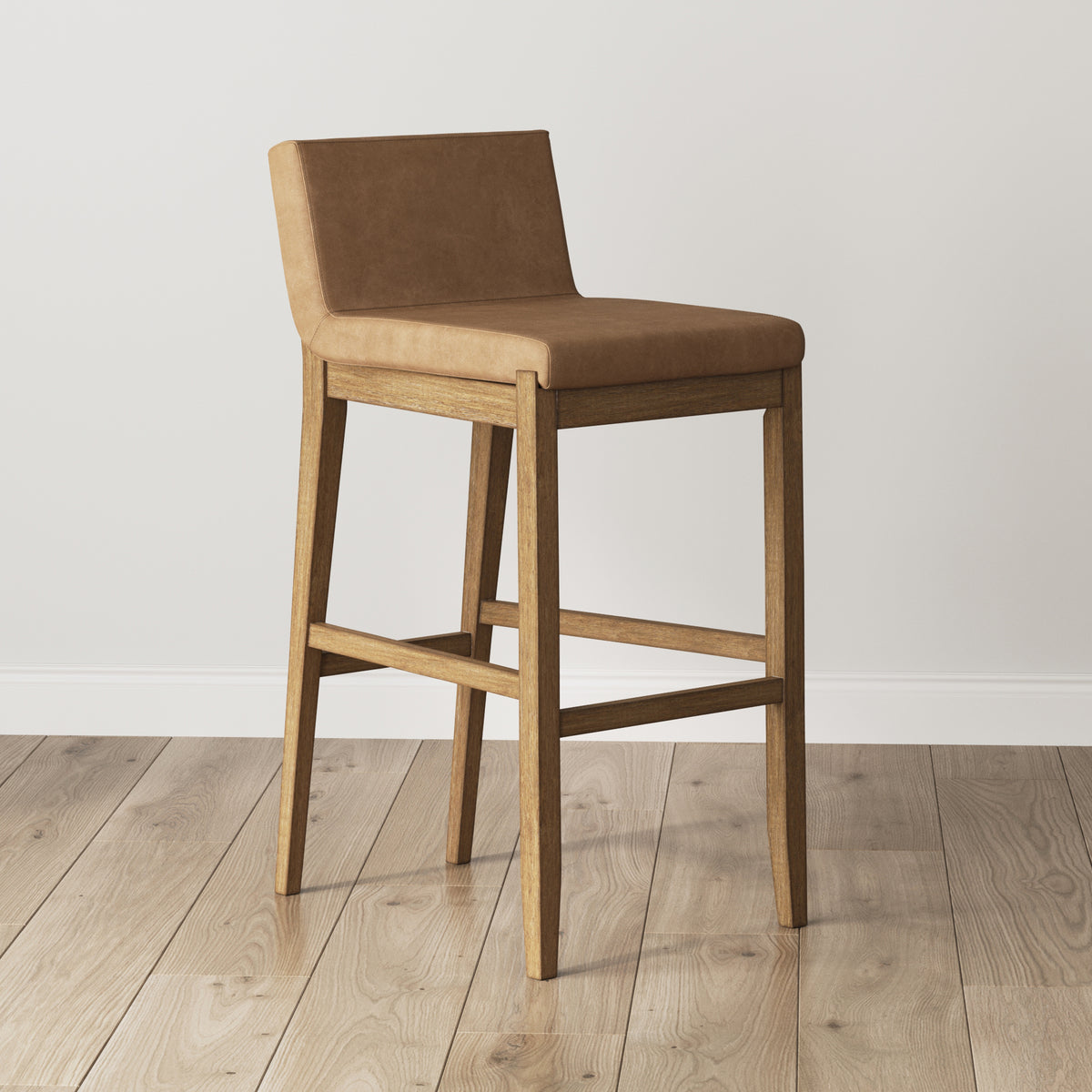 A wooden bar stool with a tan upholstered seat and backrest.