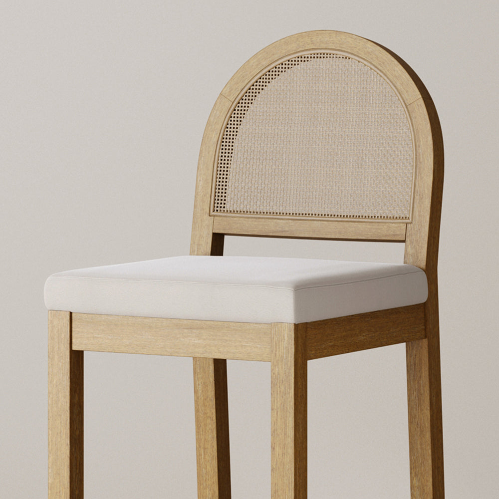 Light wood dining chair with a curved, cane-webbed backrest and a white upholstered seat.