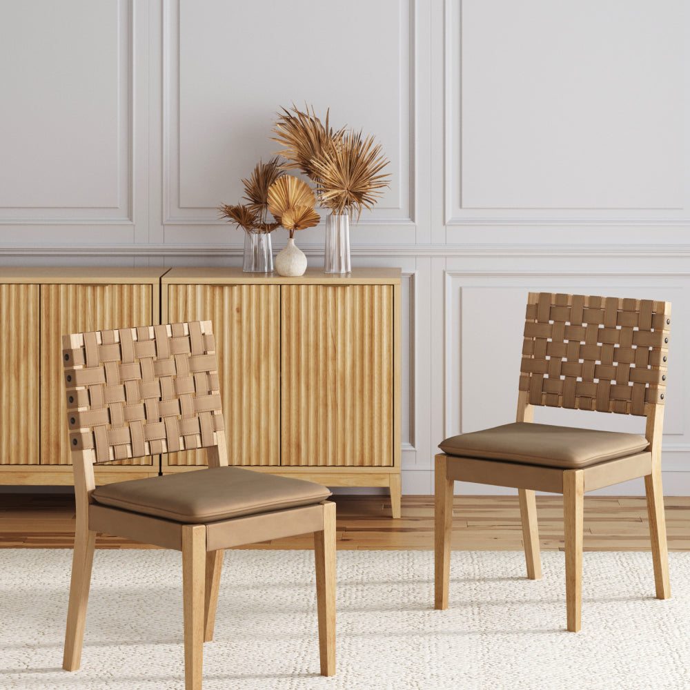 Two wooden chairs with woven tan backrests and cushioned seats in front of a fluted wooden cabinet.