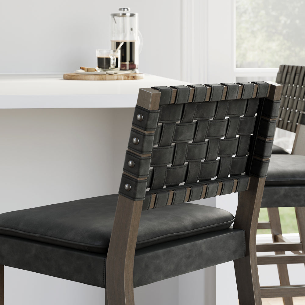 Two counter stools with dark woven leather backrests and padded seats positioned at a white counter.