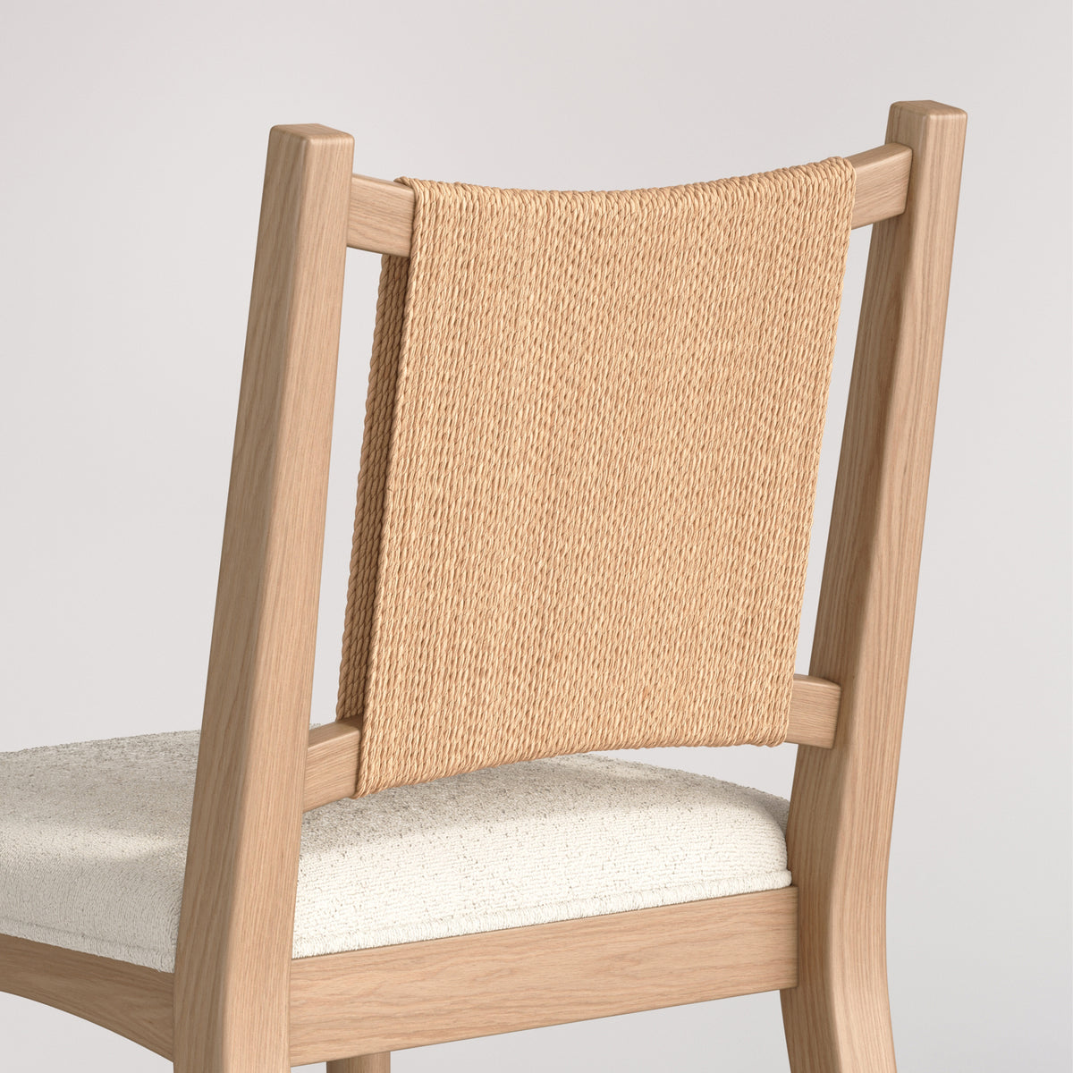 Wooden dining chair with a woven rope backrest and a textured off-white seat.