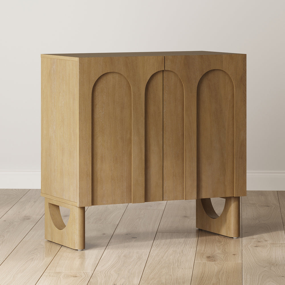 A light wood cabinet with two doors featuring arched panels and curved, open-frame legs.