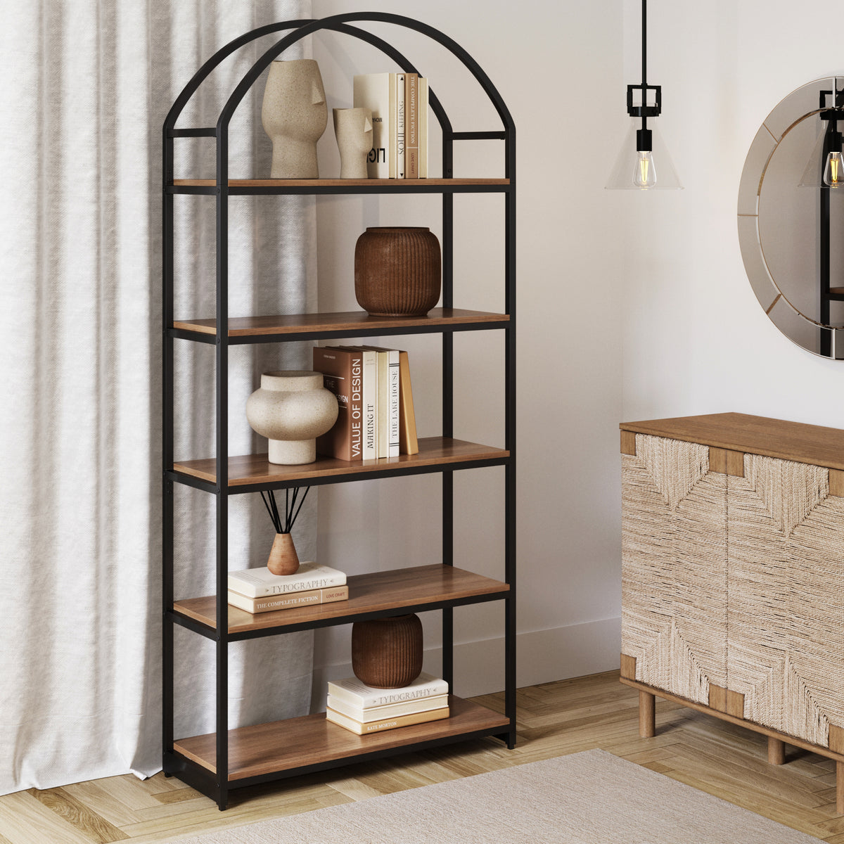 Arched black metal shelving unit with wooden shelves holding decorative vases and books.