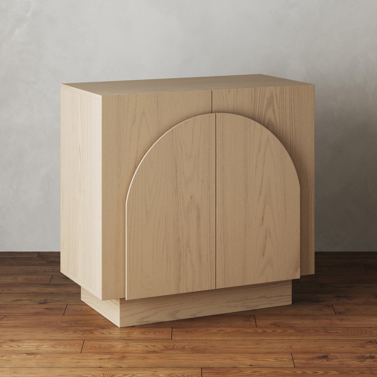 Light wood cabinet with two doors featuring arched decorative molding.