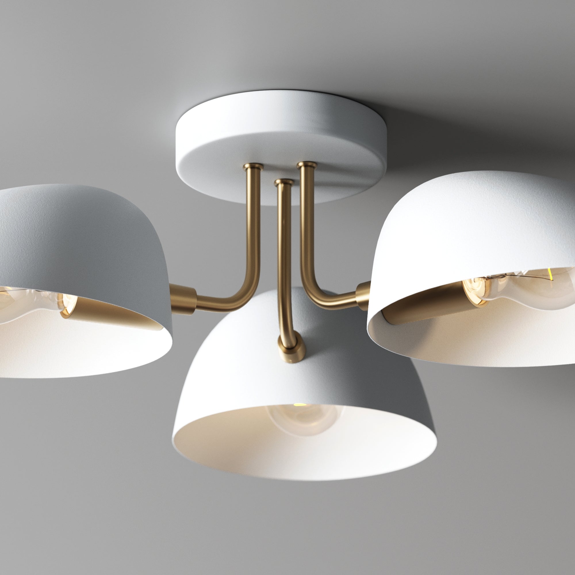 A modern ceiling light fixture with three white, dome-shaped lampshades and gold metal arms, mounted on a white circular base against a gray ceiling.