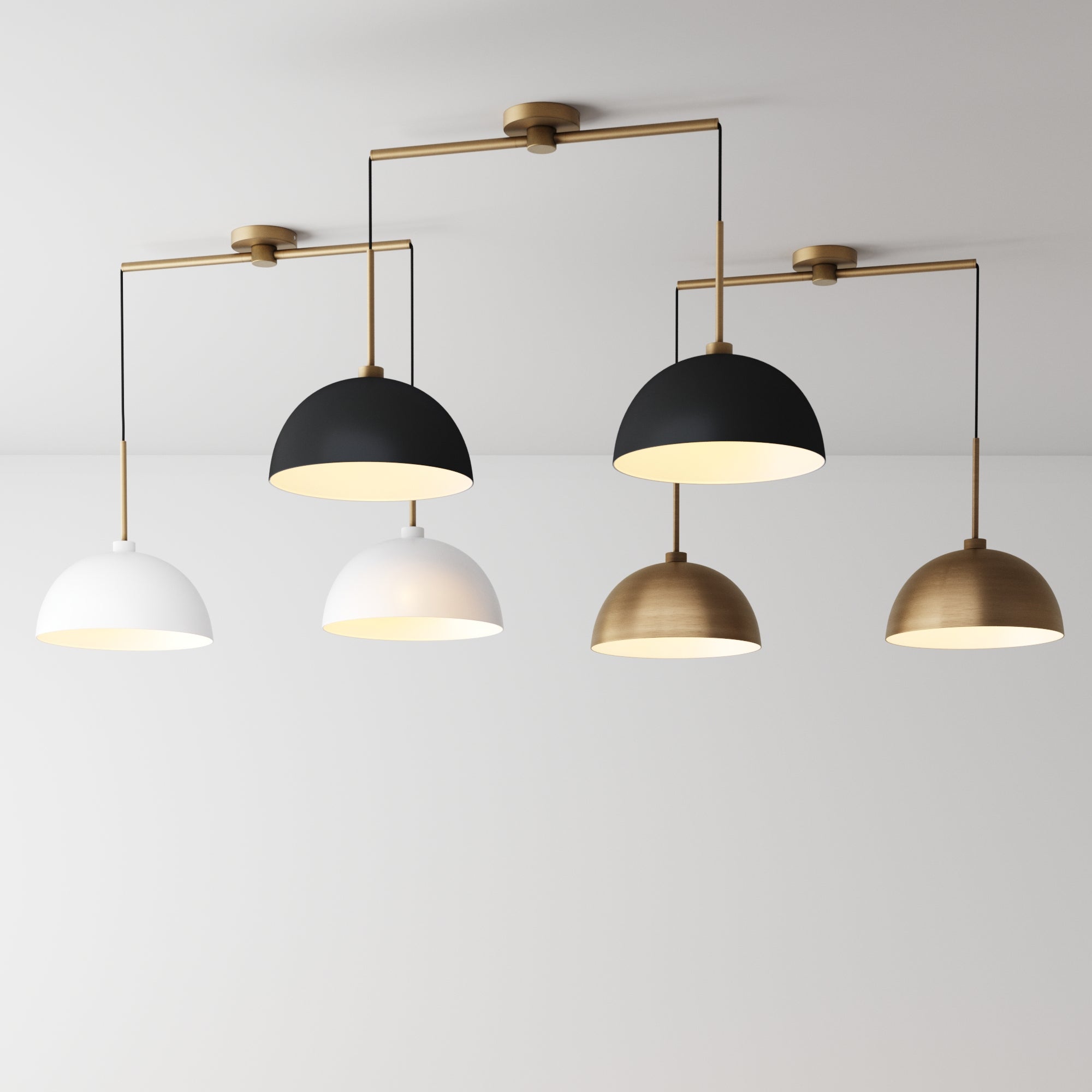 A modern ceiling light fixture with five dome-shaped pendants in black, white, and gold finishes, hanging in a row against a plain white ceiling and wall.