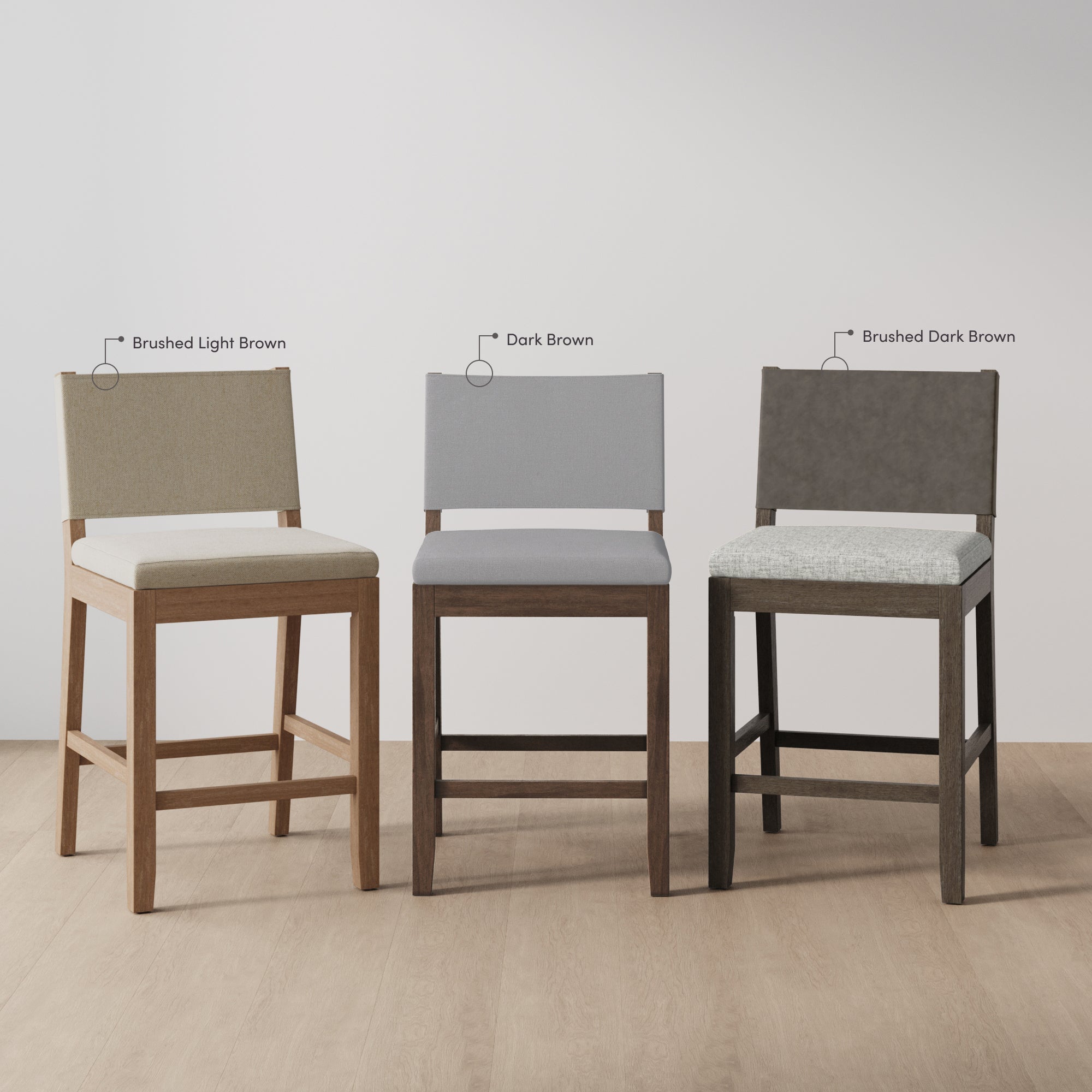 Three barstools with upholstered seats and backs in different colors: brushed light brown (left), dark brown (middle), and brushed dark brown (right), each with matching wooden legs, on a light wood floor.