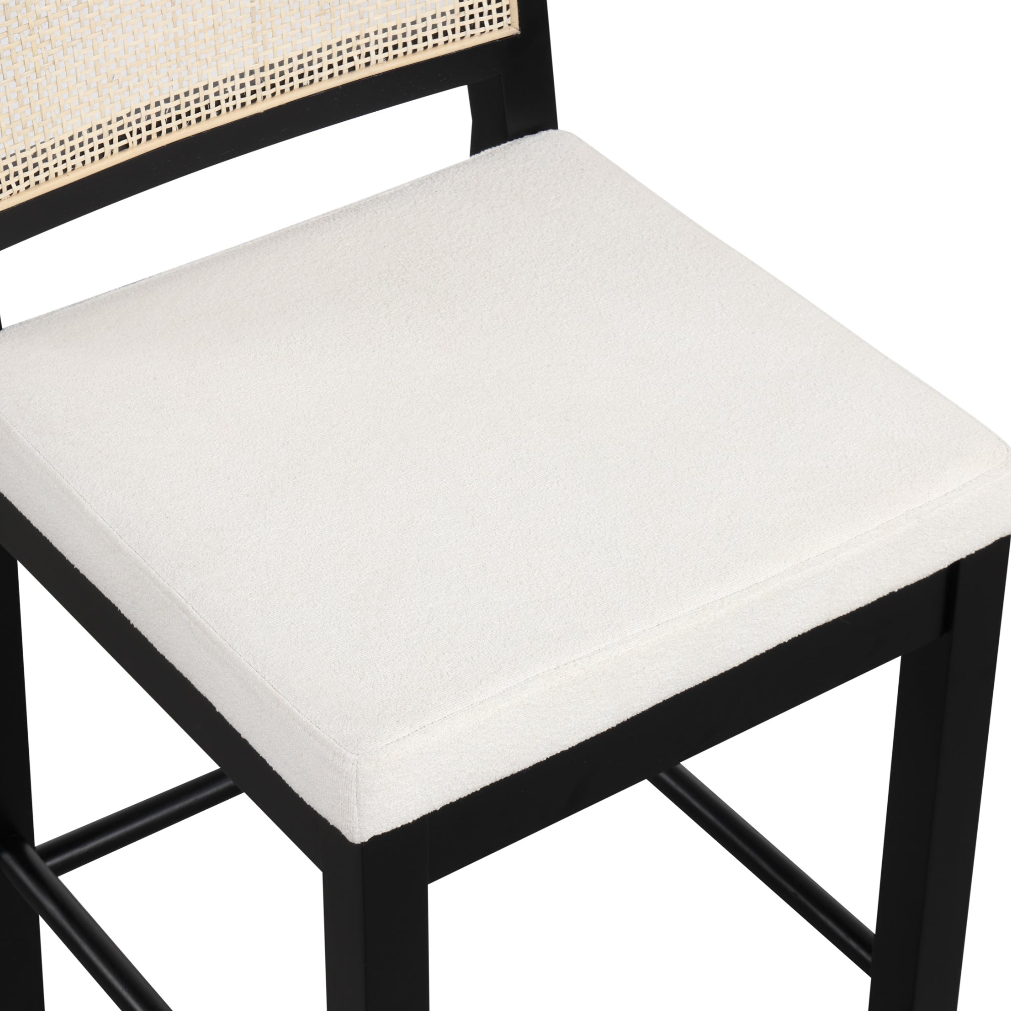 A close-up of a chair with a black wooden frame, a white cushioned seat, and part of a woven backrest visible at the top of the image.