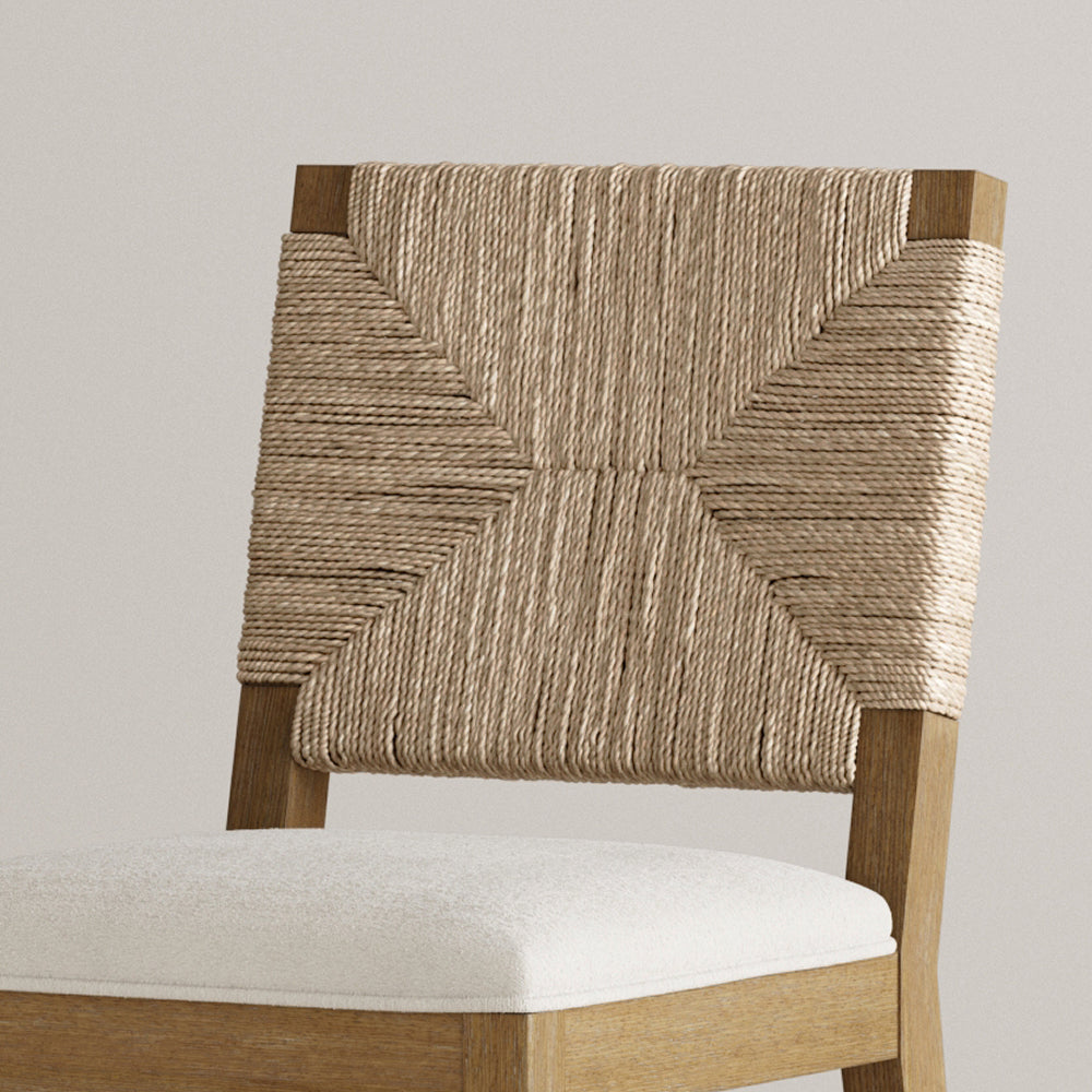 Wooden chair with a woven rope backrest and a white upholstered seat.