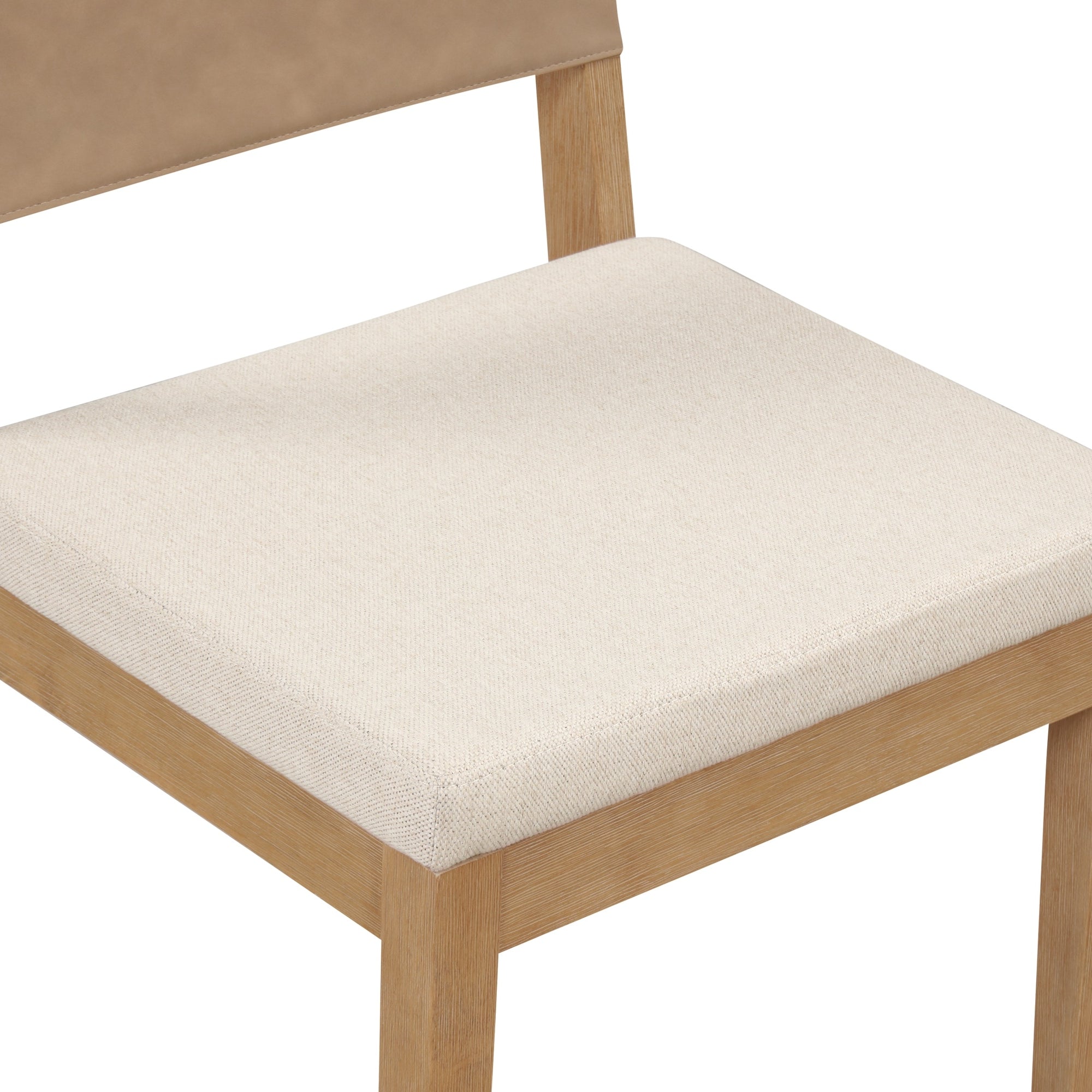 A close-up view of a wooden chair with a light-colored, textured fabric seat cushion and a tan backrest.