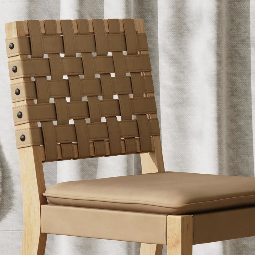 Light wood dining chair with a woven tan strap backrest and a cushioned tan seat.