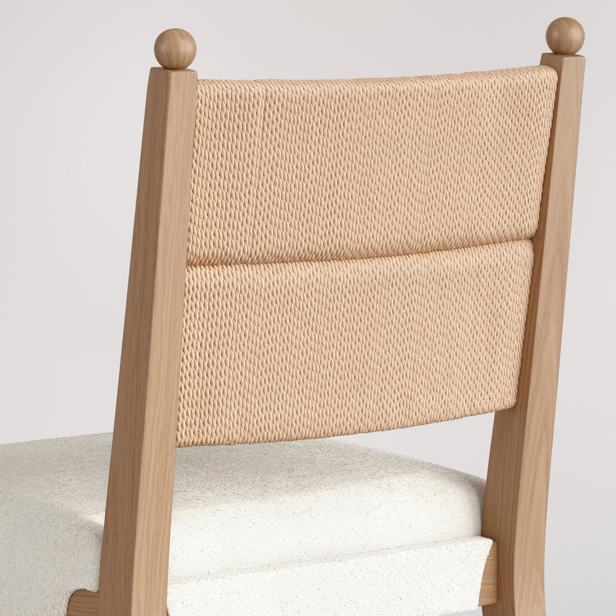 Light wood dining chair with a woven tan cord backrest and a white upholstered seat.