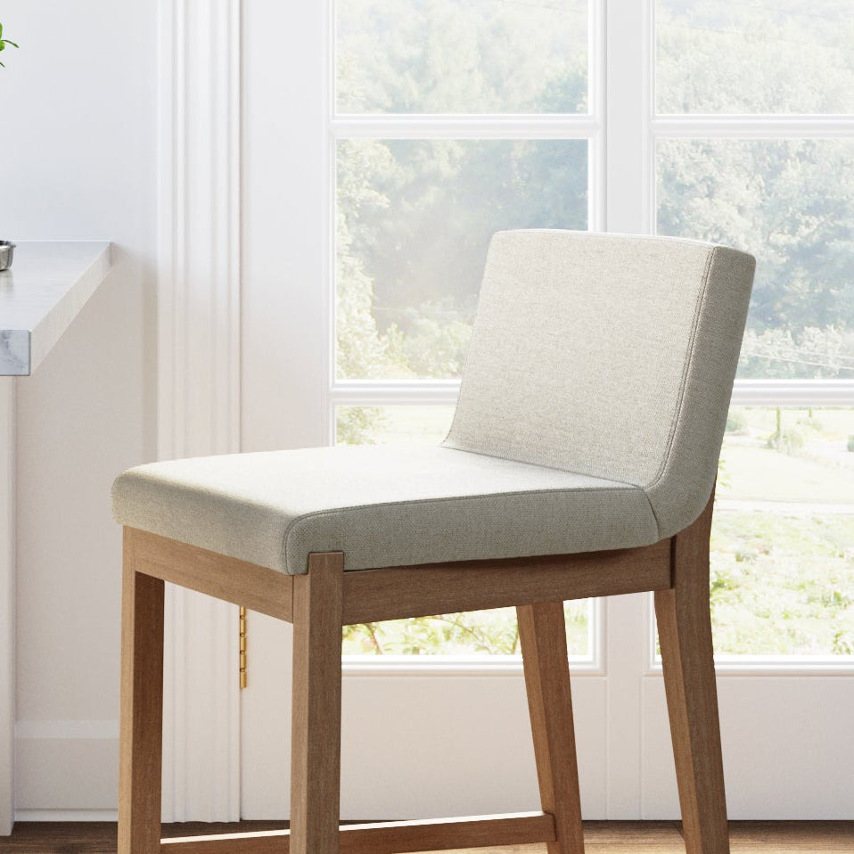 A backless bar stool with a light-colored upholstered seat and a wooden frame.
