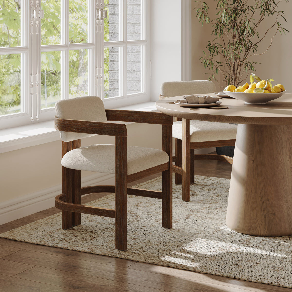 Two dark brown Nathan James Modern Boucle Wood Dining Chairs with curved backrests at a round wooden table.