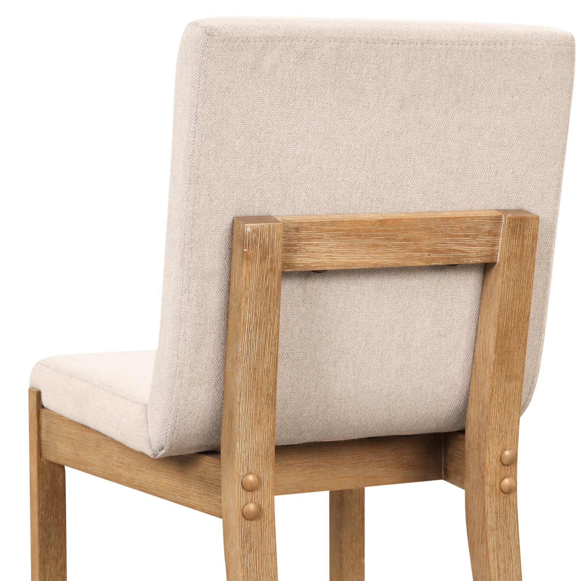 A wooden chair with a beige upholstered seat and backrest, viewed from the back at an angle. The legs and frame are light wood, and the backrest is rectangular with visible upholstery texture.