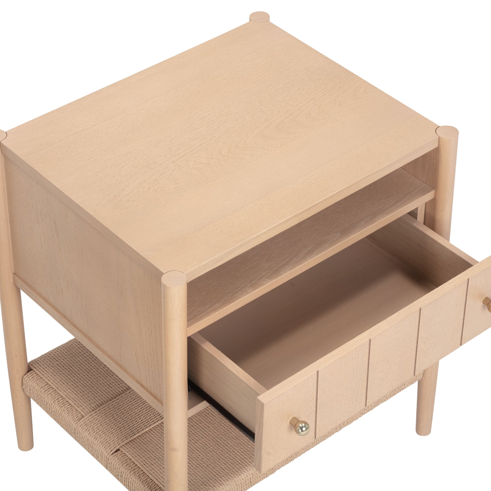 A light wood nightstand with a woven lower shelf, an open middle shelf, and a single drawer partially pulled out, featuring a round knob handle.