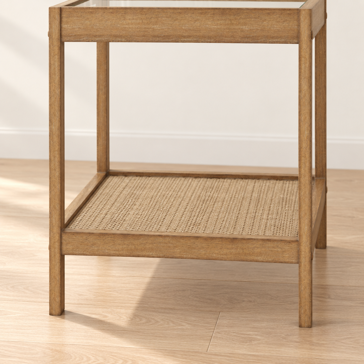 Wooden side table with a glass top and a woven rattan lower shelf.