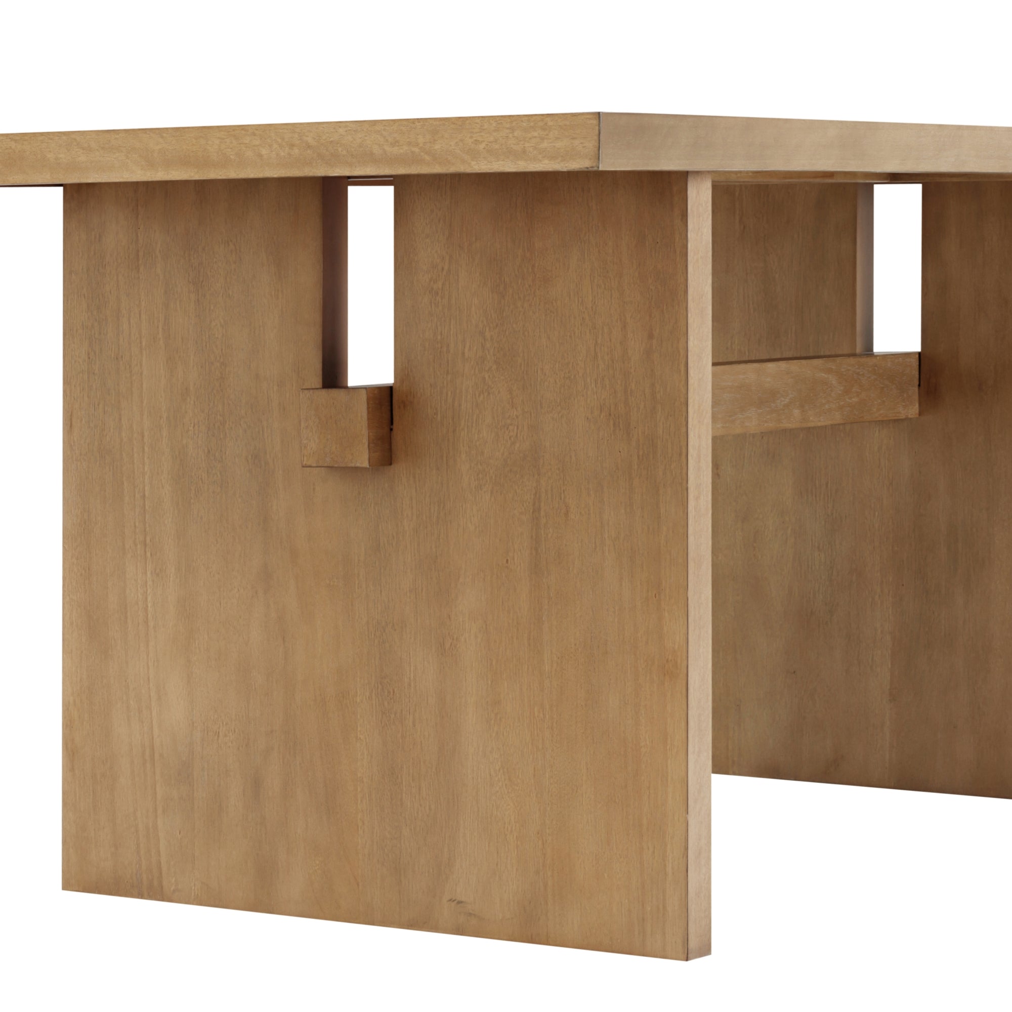 A close-up view of a modern wooden table with thick, flat legs and a rectangular top. The light brown wood has a smooth finish, and the table features square cutouts and a horizontal support bar.