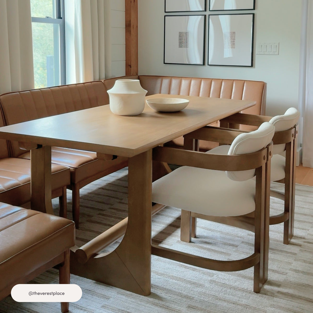 A rectangular Mid-Century Extendable Wood Dining Table for 6 Light Brown made of light wood with two white chairs, positioned next to a tan leather corner bench.