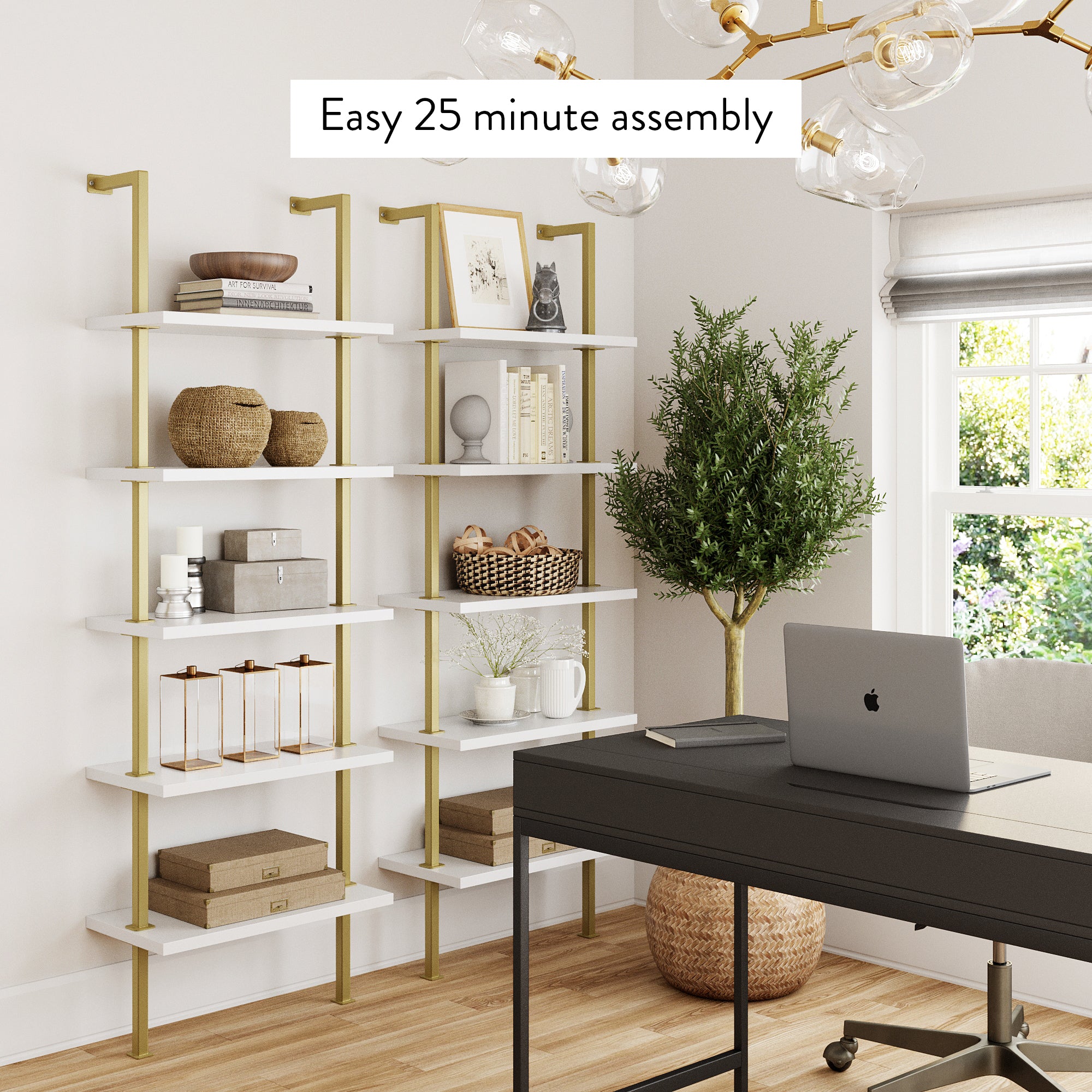 Modern home office with white and gold bookshelves holding decor items and books, a black desk, chair, potted plant, window, and gold chandelier. Text reads: “Easy 25 minute assembly.”.