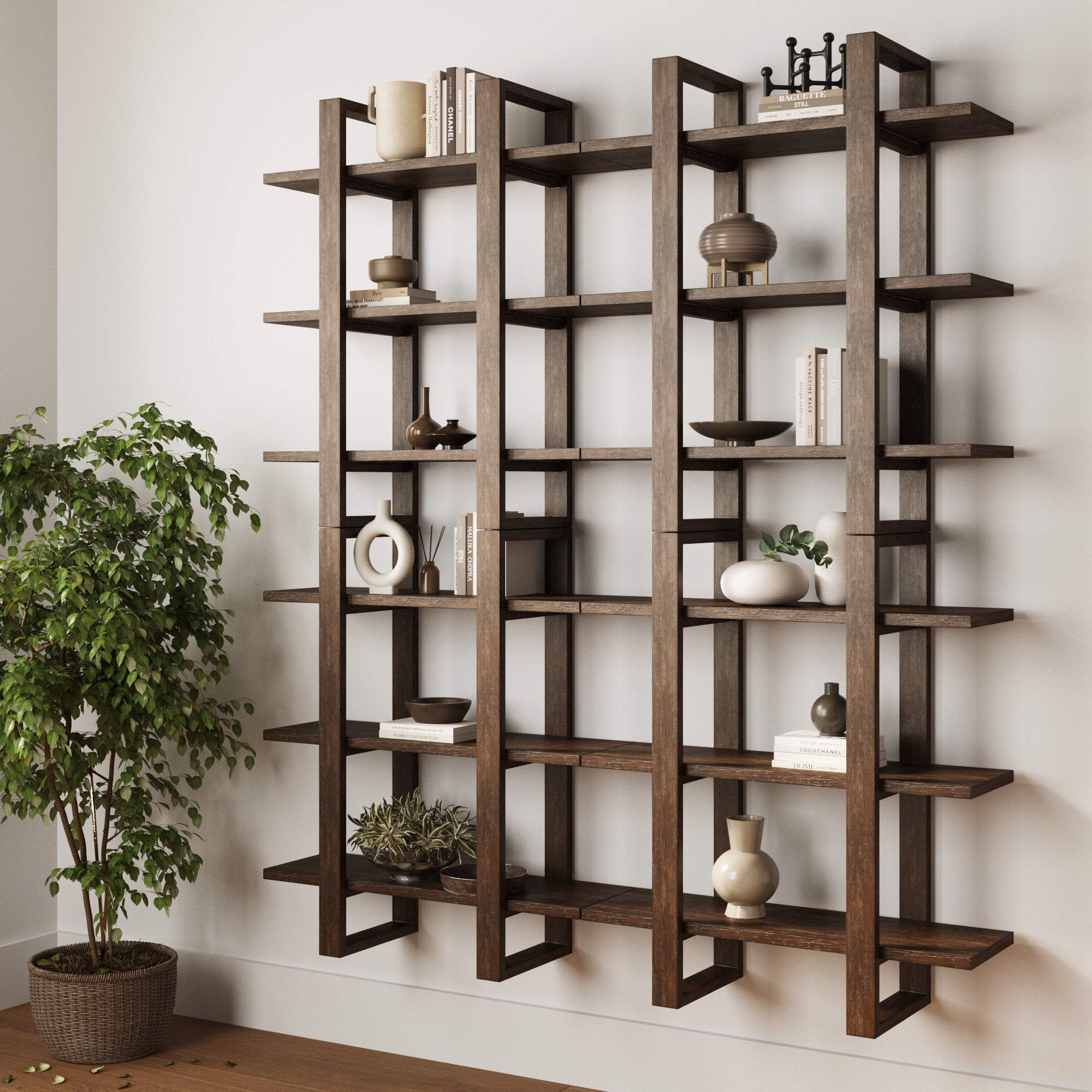 A modern, dark wood wall-mounted bookshelf holds minimalist decor items like vases, bowls, and books. A green potted plant sits on the floor beside the shelf, and the room has light-colored walls and flooring.