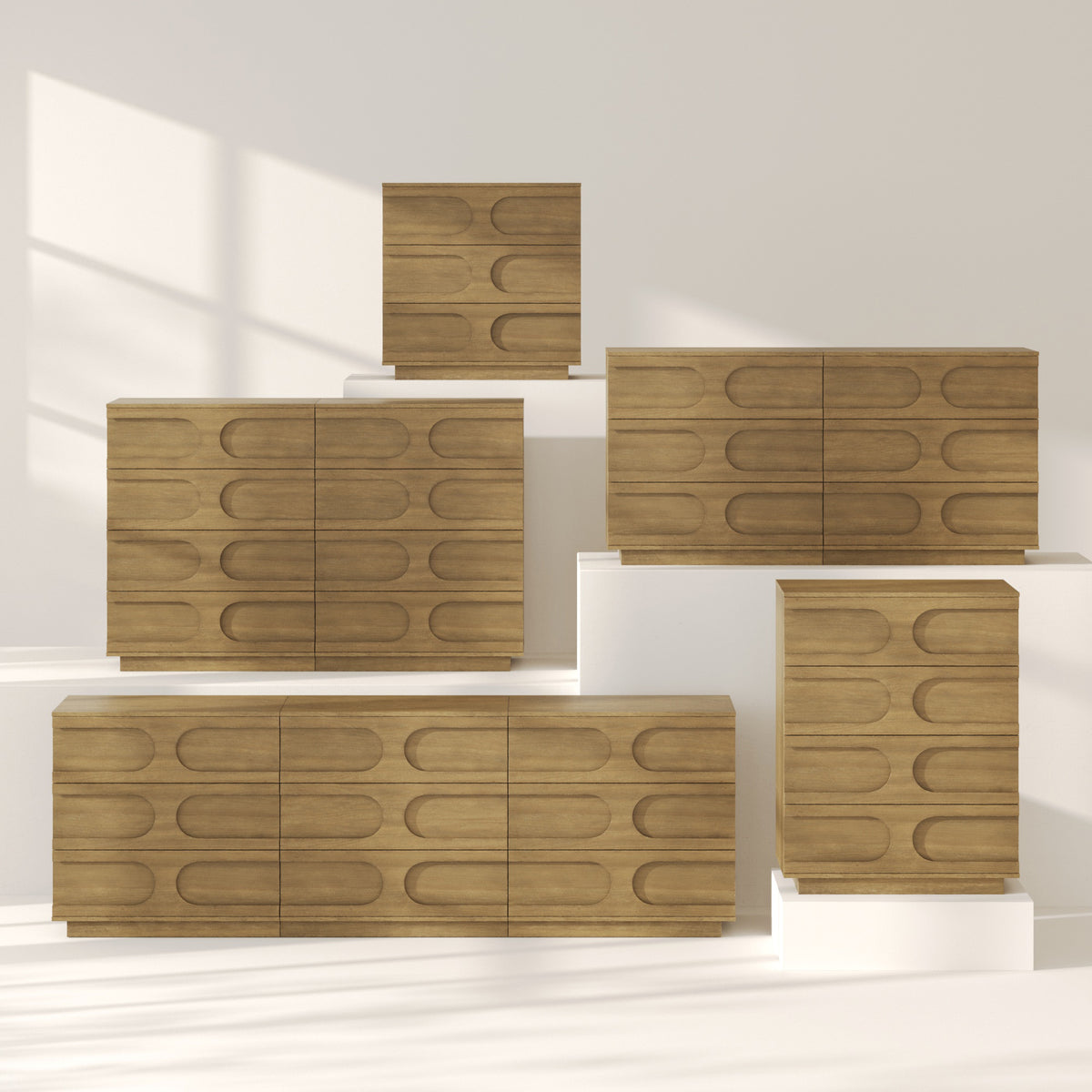 Five Nathan James Mid-Century Modern Wood Stackable 3-Drawer Dresser Brown units of various sizes displayed on white blocks, featuring horizontal drawers with elongated oval-shaped indentations.
