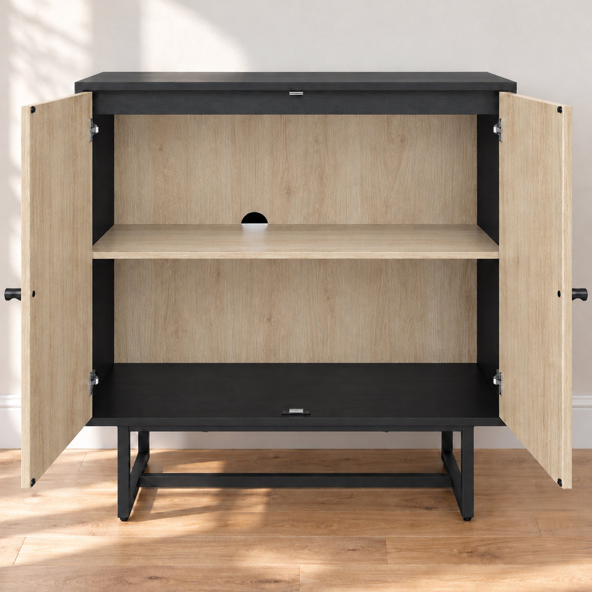 Black and light wood cabinet with two open doors, an interior shelf, and a hole for cable management.