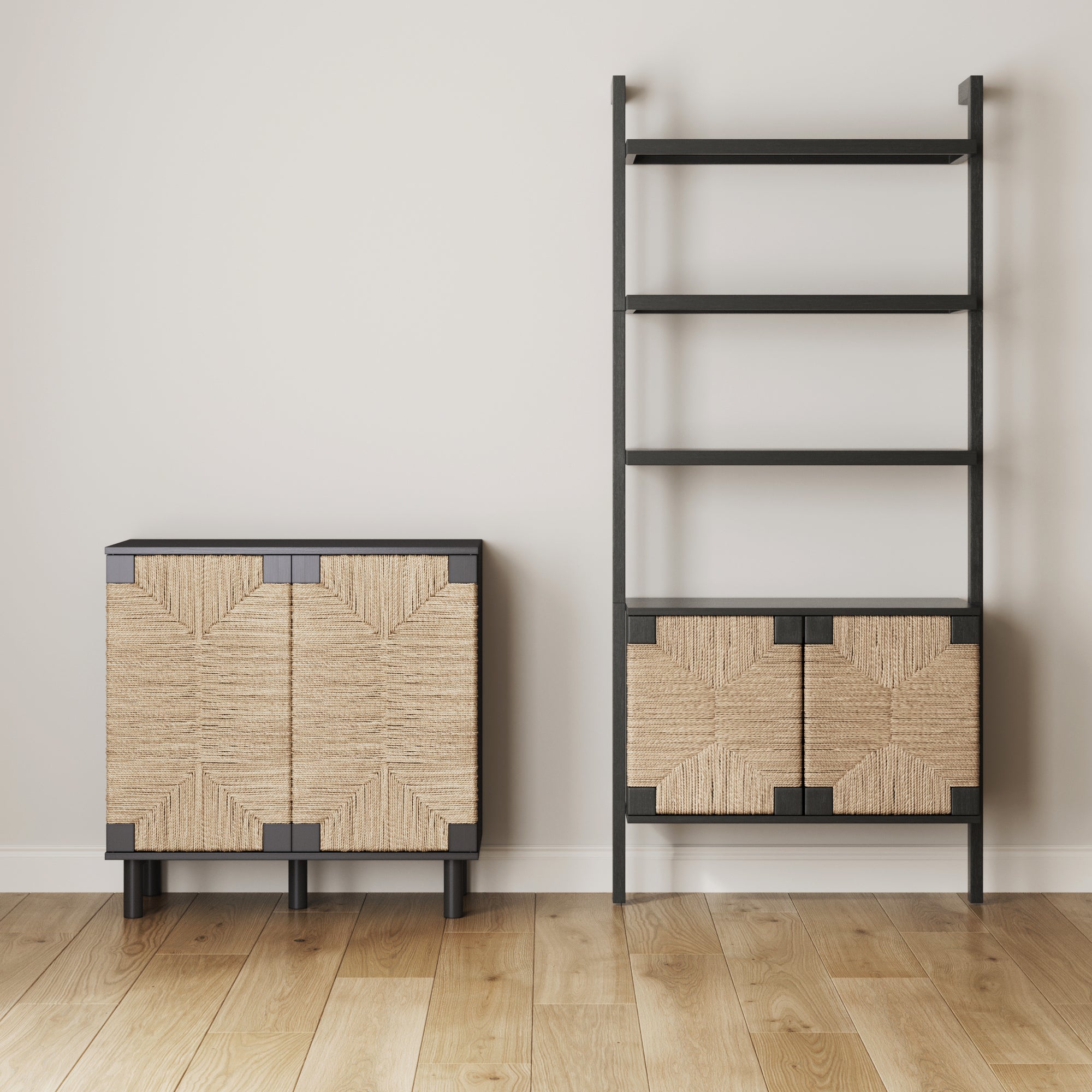 A modern, minimalist room with light wood floors features a black shelving unit with woven storage compartments and a matching cabinet with woven doors, both against a white wall.