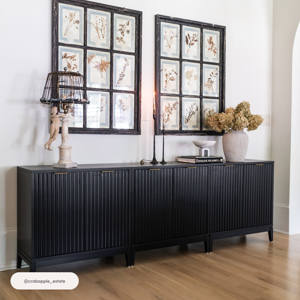 Nathan James Mid-Century Fluted TV Console for TVs up to 65″ Black with four doors against a white wall.