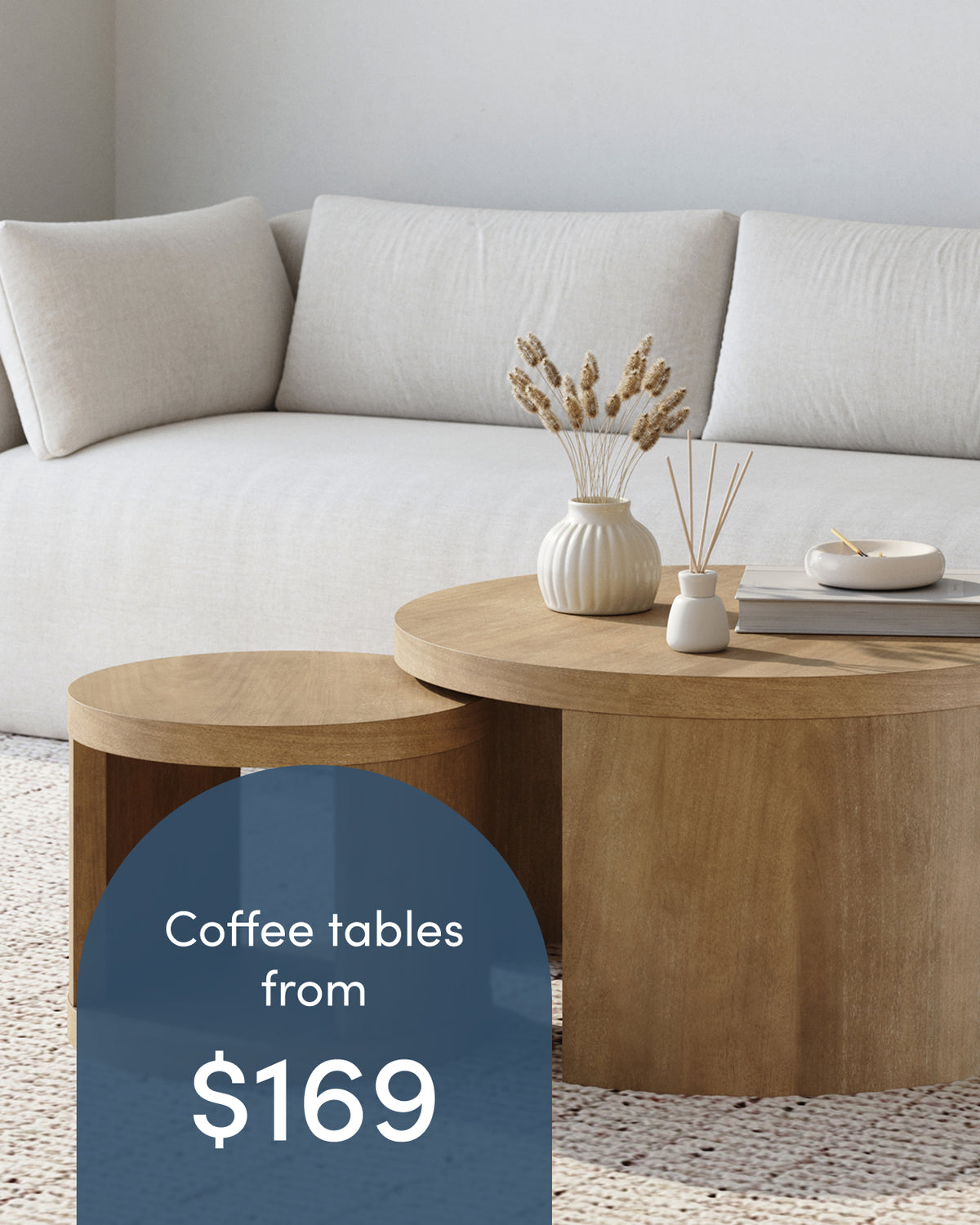Two nesting wooden coffee tables in front of a sofa, with text overlay reading Coffee tables from $169.