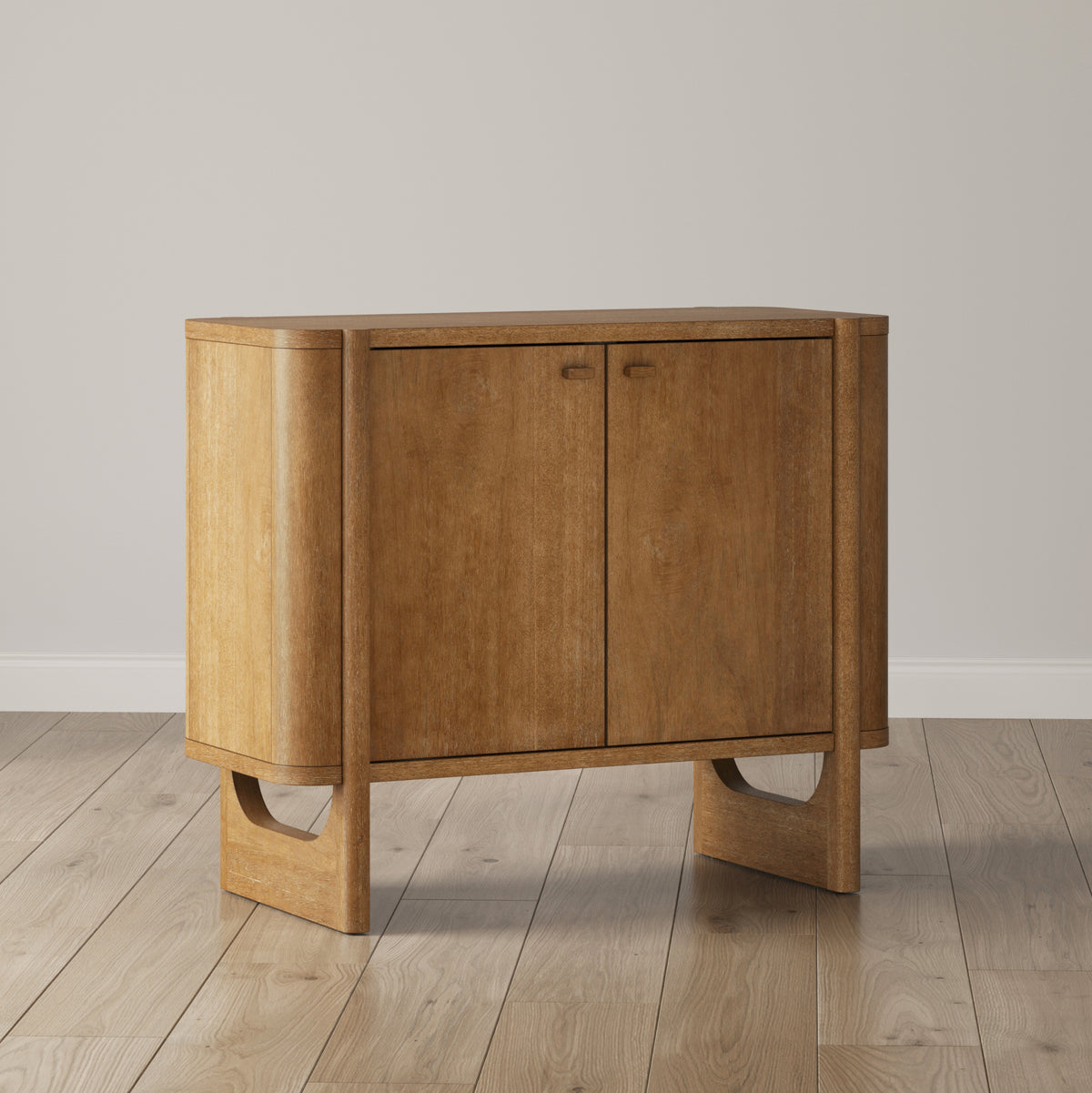A medium-toned wooden cabinet with two doors and curved sides, supported by arched legs on a wooden floor.